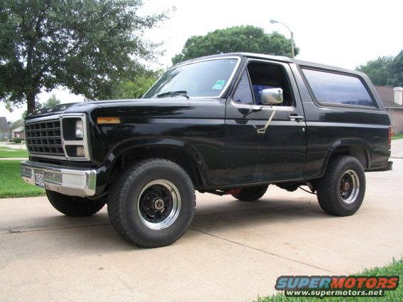 Black Ford Bronco parked on a driveway, front quarter view. It has a chrome grille and bumper