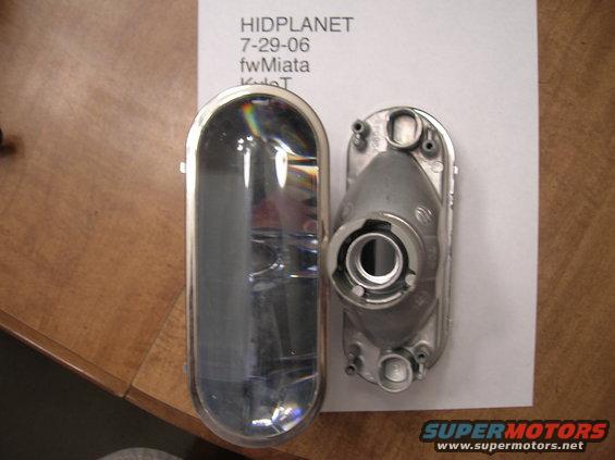 Car headlight lens and housing next to each other on a table