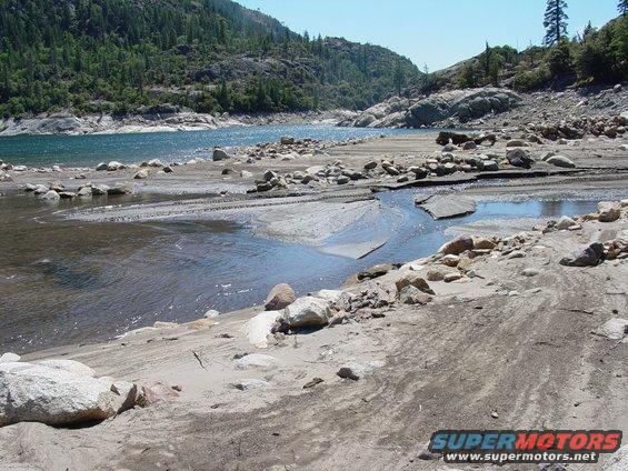 Rocky shore of a lake with a small stream flowing into it