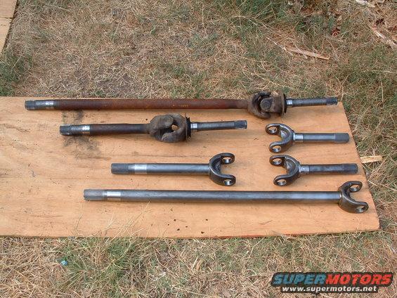 Driveshafts and U-joints laid out on a wooden board