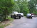 1995 Ford C-350 (Centurion Conversions) - A lifted 1978 Ford Bronco is parked in a lot with other vehicles and a trailer.