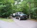 1995 Ford C-350 (Centurion Conversions) - A modified 1995 Ford Bronco is parked on a paved road, with another vehicle behind it, surrounded by trees.