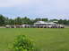 1995 Ford C-350 (Centurion Conversions) - A group of off-road vehicles are gathered in a field near a gas station.
