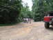1995 Ford C-350 (Centurion Conversions) - Group of people gathered on a dirt road next to a red Ford truck.