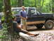 1995 Ford C-350 (Centurion Conversions) - Two men converse near a lifted Ford Bronco during an outdoor excursion in a forest.