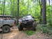 1995 Ford C-350 (Centurion Conversions) - Two off-road vehicles navigate a wooded trail during an event in July 2006.