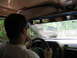 1995 Ford C-350 (Centurion Conversions) - Driving on a dirt road behind another vehicle, surrounded by trees.