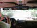 1995 Ford C-350 (Centurion Conversions) - Driving down a dirt road, with another vehicle visible ahead through the windshield.