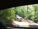 1995 Ford C-350 (Centurion Conversions) - A lifted silver truck navigates a wooded trail during an off-road excursion.