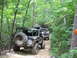1995 Ford C-350 (Centurion Conversions) - Multiple off-road vehicles navigate a wooded trail during an event in July 2006.
