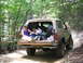 1995 Ford C-350 (Centurion Conversions) - Person relaxing in the back of a Ford Bronco on an off-road trail.