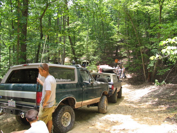 Green Ford Bronco with a sticker reading "FullSizeBronco.com" parked on a dirt trail