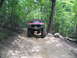 1995 Ford C-350 (Centurion Conversions) - Modified red truck navigating a challenging off-road trail in a forest setting.