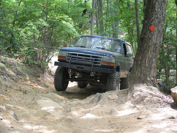 Blue SUV with aftermarket bumper on a rocky off-road trail
