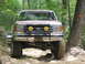 1995 Ford C-350 (Centurion Conversions) - This tan Ford truck, identified by its "MULE" license plate and "FULLSIZEBRONCO.COM" banner, navigates an off-road trail.