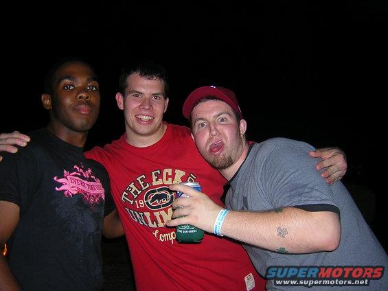 Three men posing for a photo at night