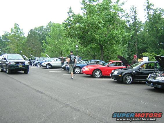 Red sports car parked in a lot with other vehicles
