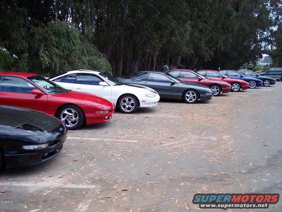 Line of red, white, and gray Ford Probes parked side-by-side