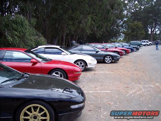 Several Ford Probe cars parked in a row, black, red, white, and gray models visible