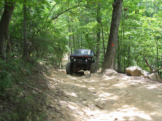 Black off-road truck with large tires on a dirt trail