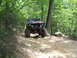 1995 Ford C-350 (Centurion Conversions) - Modified truck navigates a challenging off-road trail through a wooded area.