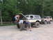 1995 Ford C-350 (Centurion Conversions) - Three men work on the hood of a lifted Ford Bronco, with another Bronco parked behind it.