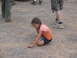 1995 Ford C-350 (Centurion Conversions) - A young girl with braided hair plays on a gravel surface, with adults standing in the background.