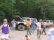 1995 Ford C-350 (Centurion Conversions) - A group of people stand around a lifted Ford Bronco with its hood up, with another SUV in the background.