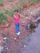 1995 Ford C-350 (Centurion Conversions) - A young girl stands on a muddy bank near the water, adjusting her ear.