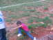 1995 Ford C-350 (Centurion Conversions) - A young girl in a pink shirt and blue jeans is captured in motion on a grassy, reddish-brown terrain.