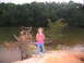 1995 Ford C-350 (Centurion Conversions) - A young girl poses by a lake with a large fallen tree in the foreground.