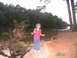 1995 Ford C-350 (Centurion Conversions) - A young girl with braided hair smiles by the water's edge, with a fallen tree nearby.