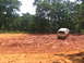 1995 Ford C-350 (Centurion Conversions) - A yellow pickup truck with a camper shell navigates a muddy terrain, with another vehicle visible in the background.
