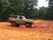 1995 Ford C-350 (Centurion Conversions) - A 1995 Ford Bronco is stuck in thick mud off-road.