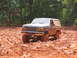 1995 Ford C-350 (Centurion Conversions) - Muddy 1995 Ford Bronco navigating a challenging off-road trail.