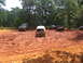 1995 Ford C-350 (Centurion Conversions) - Multiple off-road vehicles navigate a challenging muddy terrain during an outdoor event.