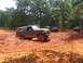 1995 Ford C-350 (Centurion Conversions) - A green Ford Bronco navigates a muddy off-road course, with other vehicles and an ATV visible in the background.