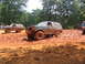1995 Ford C-350 (Centurion Conversions) - Multiple off-road vehicles navigate a muddy track during an event.