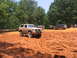 1995 Ford C-350 (Centurion Conversions) - Several off-road vehicles navigate a dirt track during an event.