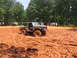 1995 Ford C-350 (Centurion Conversions) - Off-road vehicle tackles a challenging muddy terrain with spectators watching from a distance.