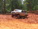 1995 Ford C-350 (Centurion Conversions) - A lifted Ford Bronco navigates a muddy off-road course, with another vehicle visible in the background.