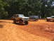 1995 Ford C-350 (Centurion Conversions) - A heavily modified Ford Bronco with oversized tires navigates a muddy off-road course alongside other vehicles.