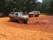 1995 Ford C-350 (Centurion Conversions) - Two off-road vehicles are seen navigating a muddy terrain under a clear sky.