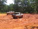 1995 Ford C-350 (Centurion Conversions) - Multiple off-road vehicles navigate a muddy terrain during an event in July 2006.