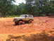 1995 Ford C-350 (Centurion Conversions) - A lifted Ford Bronco navigates a muddy off-road course, with another vehicle visible in the distance.