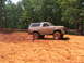1995 Ford C-350 (Centurion Conversions) - A tan Ford Bronco with off-road tires navigates a muddy track during an event in July 2006.