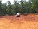 1995 Ford C-350 (Centurion Conversions) - Off-road vehicle driving through thick mud on a sunny day.