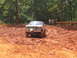 1995 Ford C-350 (Centurion Conversions) - A Ford Bronco II navigates a muddy off-road course with spectators watching.