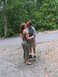 1995 Ford C-350 (Centurion Conversions) - A couple shares a kiss on a wooded road.