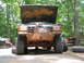 1995 Ford C-350 (Centurion Conversions) - Muddy lifted truck with hood open, parked outdoors with trees in the background.
